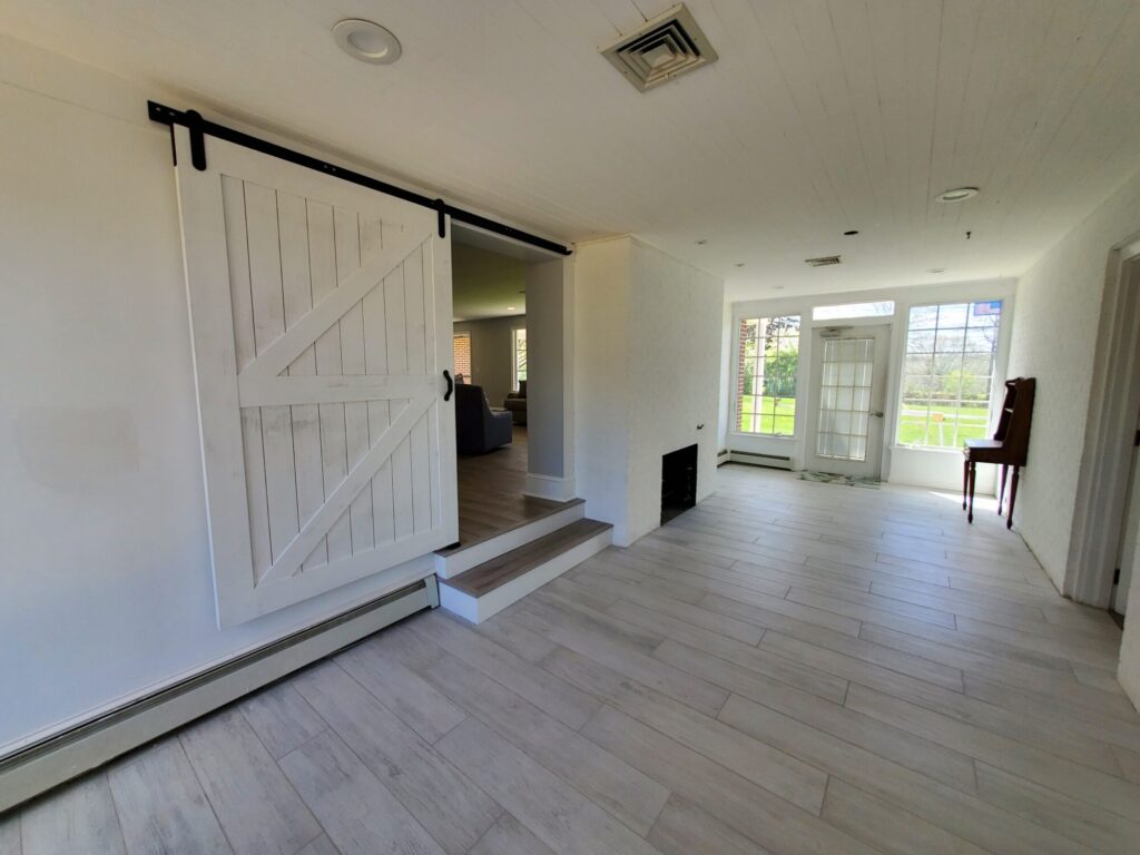 an enclosed breazeway with sliding barndoors as part of addition project for a rancher home